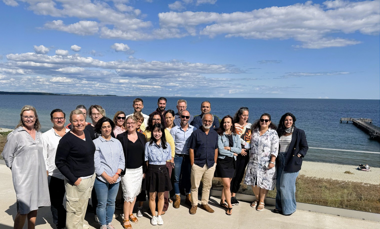 The CMES staff standing outside on a beach smiling to the camera